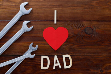 Father's day concept. Tools on a wooden background with wooden letters -I love dad. Copy space