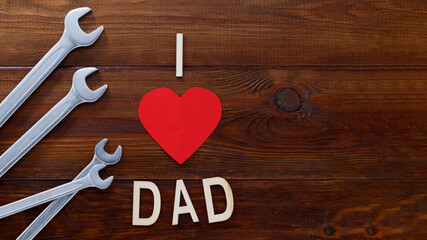 Father's day concept. Tools on a wooden background with wooden letters -I love dad. Copy space