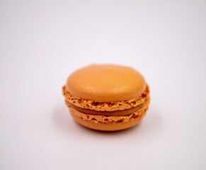 Colorful orange macaroon on white background, isolated on