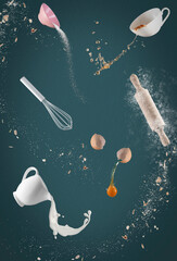 Bake goods, ingredients fly around on green, blue background, concept baking chaos, baking in the kitchen, photo manipulation
