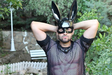 Seductive man with bunny mask and see through mesh shirt