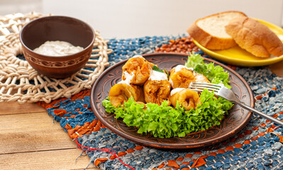 Ukrainian national dish golubtsy: Cabbage rolls with meat, rice and vegetables in a ceramic plate on wooden background. Side view
