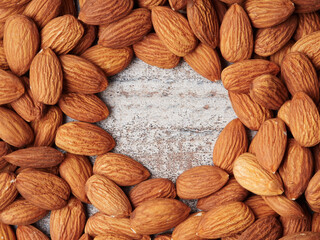 Almond in a bowl on wooden background with copy space