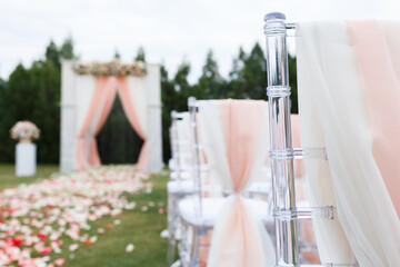 Transparent stylish plastic chairs. Luxury decor for the white wedding ceremony.