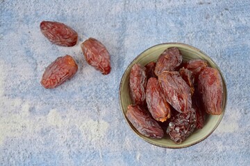 Fresh raw organic Medjool dates on blue background, flat lay