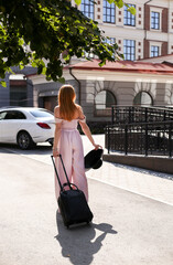 Open borders after isolation allow a girl in a dress with a suitcase to go to her favorite country...