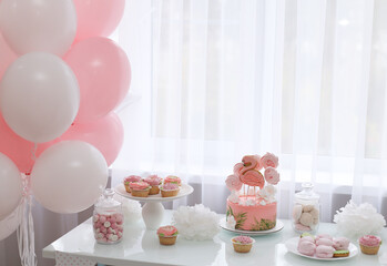 Pink cakes and pink balloons welcome guests to the party
