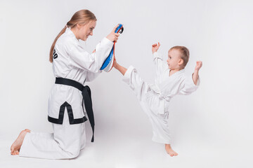 Mother her little son practicing martial arts over white background. © Vulp