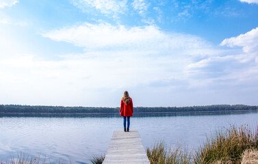 Girl in a red coat by the lake