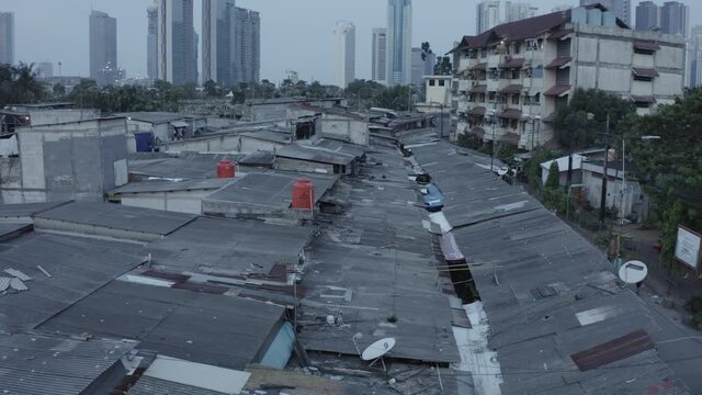 Aerial drone shot tilting up from slums to large modern skyscraper skyline