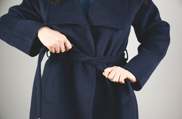 woman holding coat belt