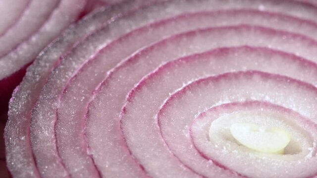 Sliced red onion rings rotating in 4K. Closeup top view of healthy food background with vegetable of rich vitamin