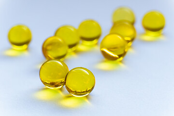 Round tablets of vitamins A and E on a white background. Scattered pills close-up. Round yellow...