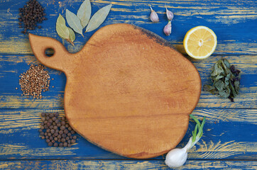 Brown board with free copy space for text decorated with spices and herbs. Top view of spices texture background