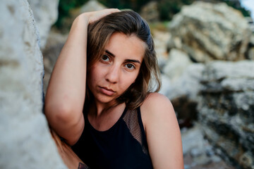 Brunette girl portrait near big mountain rocks