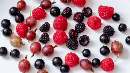 Assorted berries of raspberries, gooseberries, currants on a white background