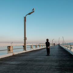 Boy staring at a seagull on the wooden pier of Nieuwpoort in Belgium.