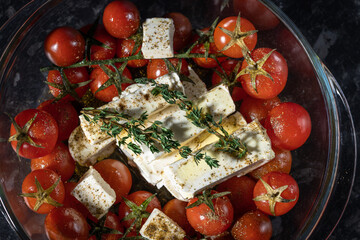 Homemade feta pasta, oven baked cherry tomatoes and feta cheese with olive oil, garlic and thyme,...