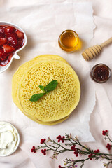 Homemade traditional moroccan baghrir with honey, strawberries and mint from above