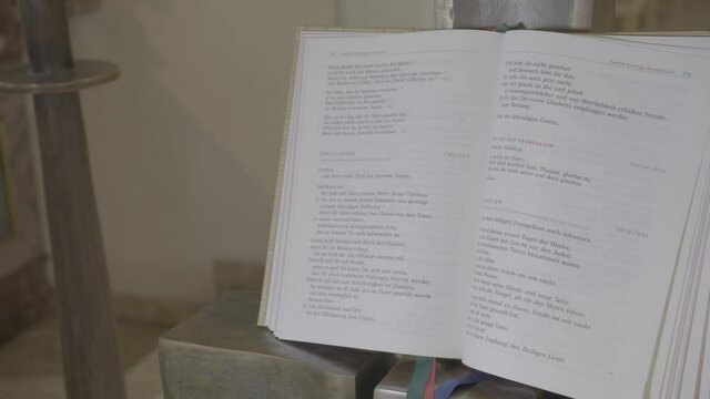 Opened gospel book, displayed on an ambo in a church