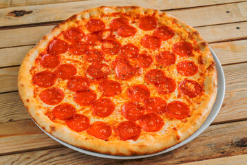 Fresh baked pepperoni pizza on the wooden background