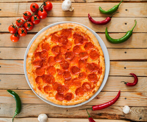 Fresh baked pepperoni pizza on the wooden background