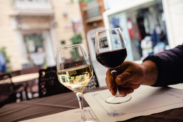 White and red wine glasses. Outdoor restaurant in old town street of Cadiz, Andalusia, Spain.