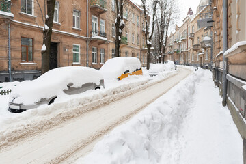 huge piles of snow covered cars on the streets of the old city after an abnormal snowfall