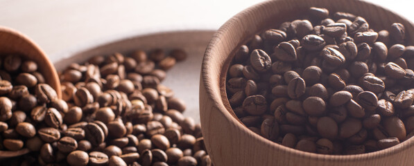 Dark Coffee Beans in a wooden Cup. Symbolic image. Rustic wooden background. Close up. Copy space.