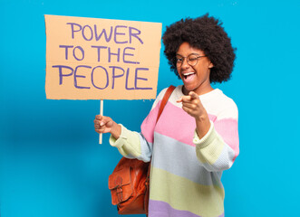 young pretty afro woman protesting with  a power to the people banner