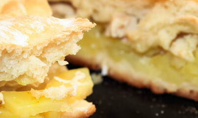 Macro photo of a cut-off pie made of yeast dough with potatoes.