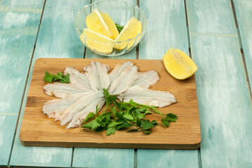 Fresh lemon anchovies without bones with parsley on a table on blue wooden background