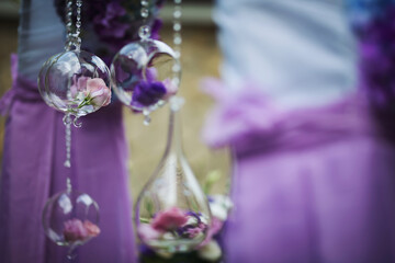 Decorated bottles with flowers hanging on twine