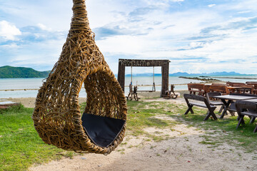 Round Swing on on a sandy beach with sea water background