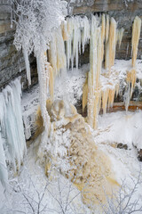Fototapeta na wymiar Beautiful frozen waterfall. Cascading icicles. Valaste waterfall is the highest waterfall in Estonia. Selective focus.