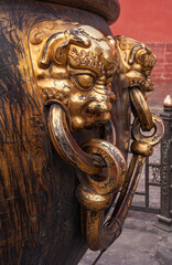 Beijing, China - April 27, 2010: Forbidden City. Closeup of 2 golden lion head handles on large...