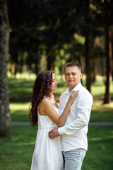 Fototapeta premium young couple in love is hugging in the park on a summer day. man and woman outdoors