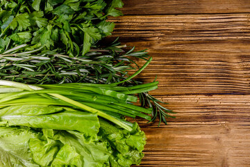 Lettuce rosemary and parsley on a wooden table. Vegan food. Top view