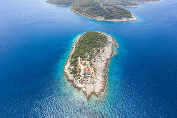 Aerial drone shot of Host Island in Adriatic sea near town port of Vis Island in Croatia summer