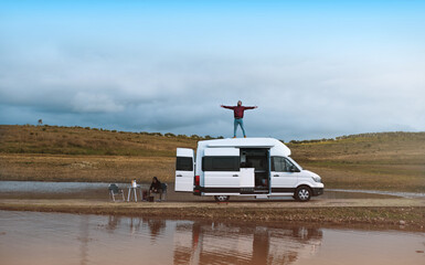 Young people in a motorhome campervan on adventure next to the river having a good time, travel, digital nomad and remote work concepts