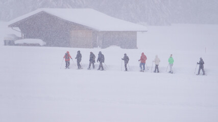 Gruppe bei einer Schneeschuhwanderung in dichtem Schneetreiben