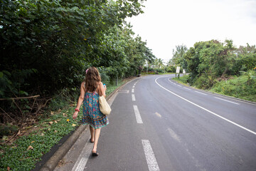 Fototapeta na wymiar Woman walks down road on the tropical island of Moorea