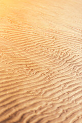 the sea sand on the coast lies in a wavy pattern formed from the water