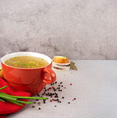 hot homemade chicken broth with collagen and amino acids in red bowl