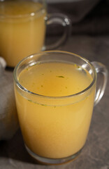 hot homemade chicken broth with collagen and amino acids in a transparent glass cup