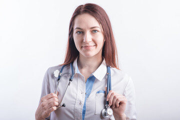 Portrait of a young female doctor in a white uniform in the studio on a white background