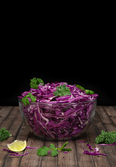 Fototapeta na wymiar Red cabbage salad in bowl with olive oil, lemon and cilantro