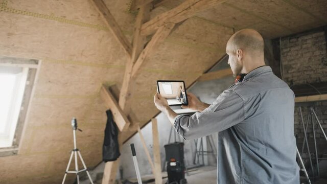 Worker filming his construction site with a tablet computer