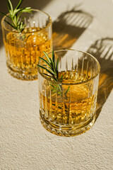 Whiskey in two glasses, decorated with rosemary