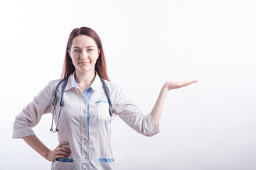 Portrait of a female doctor in a white uniform that shows a palm with copyspace in the studio on a white background